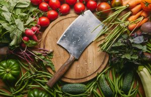 What is a Vegetable Cleaver Used for? metal cleaver on cutting board with organic green and red vegetables