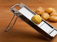 The Best Mandoline Slicers for Perfectly Sliced Sweet Potatoes Half a potato on a mandolin slicer