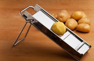 The Best Mandoline Slicers for Perfectly Sliced Sweet Potatoes Half a potato on a mandolin slicer