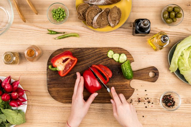 woman cutting a red pepper